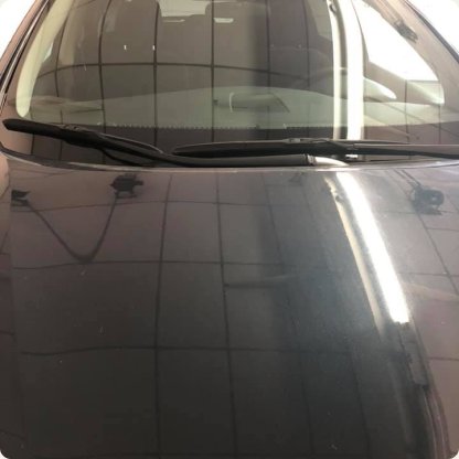 Close-up of a freshly installed windshield on a dark vehicle