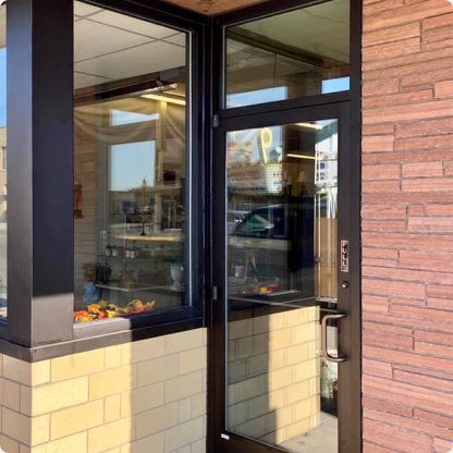 Commercial glass entry door and storefront on a brick and stone building