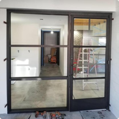 Black grid-framed glass double doors installed in a new commercial interior