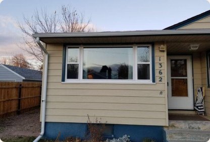 Tan ranch home with a new white-framed picture window