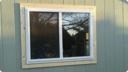 New sliding window with fresh trim on blue-gray siding